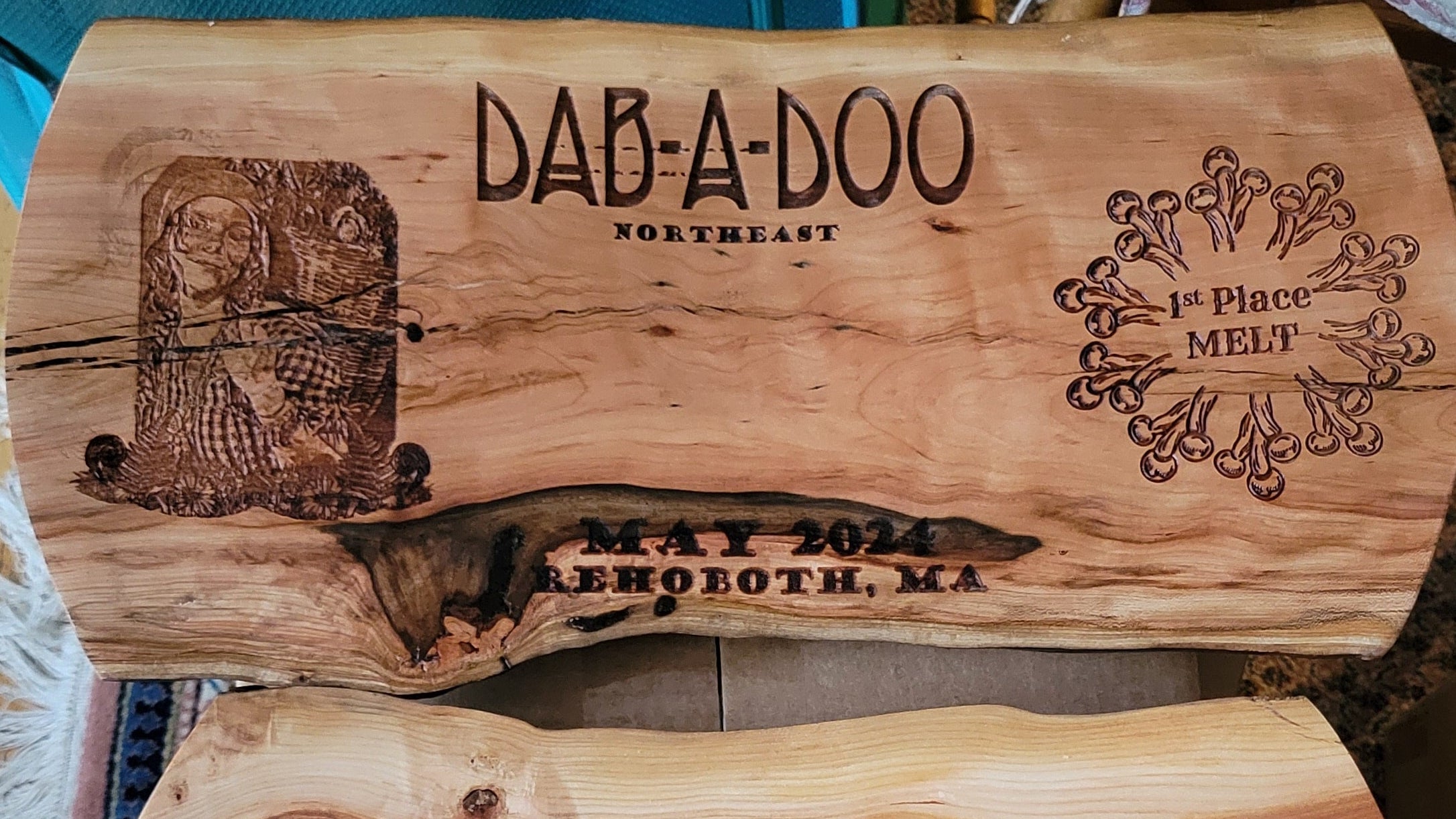 Two custom live-edge wooden plaques engraved with 'DAB-A-DOO NORTHEAST' and May 2024 Rehoboth, MA dates, displayed on a patterned rug.